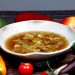 Bowl of vegetable soup with colorful fresh produce.