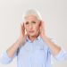 Senior woman holding her ears in discomfort.