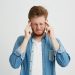 Man in denim shirt holding head in frustration