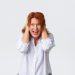 Woman expressing stress with hands on head.