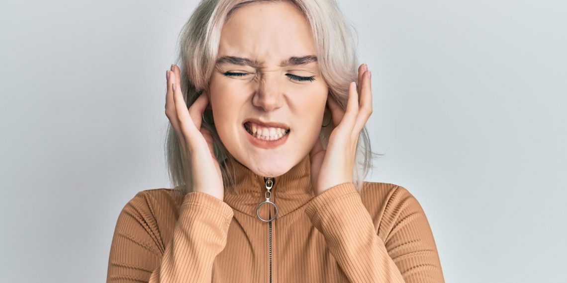 Woman covering ears in frustration.
