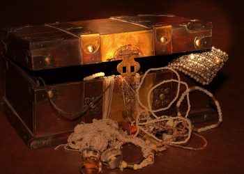 Antique treasure chest filled with jewelry and gold.