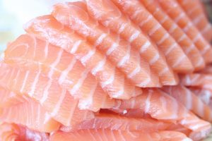 Slices of fresh salmon fillet neatly stacked.