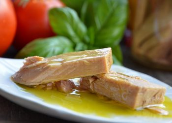 Juicy tuna slices garnished with olive oil on a white plate.