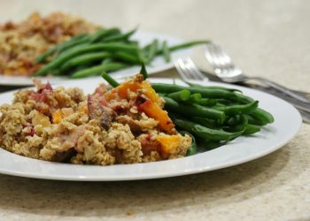 Scrambled tofu with colorful veggies and green beans on a white plate.