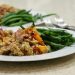 Scrambled tofu with colorful veggies and green beans on a white plate.