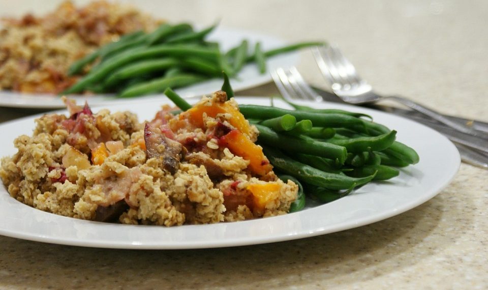 Scrambled tofu with colorful veggies and green beans on a white plate.