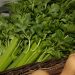 Fresh celery stalks in a wicker basket at a market.