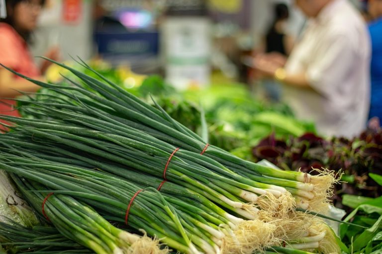 Fresh green onions stacked at market.