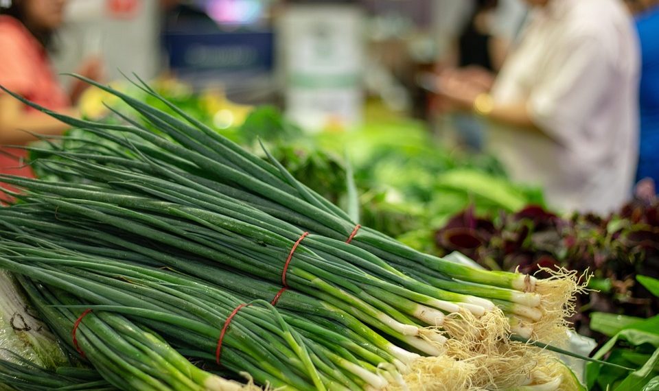 Fresh green onions stacked at market.