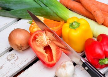 Vegetables and knife on wooden table.