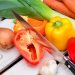 Vegetables and knife on wooden table.