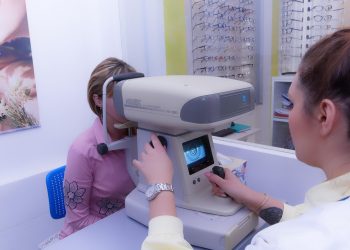 Eye exam with autorefractor machine in optometry clinic.