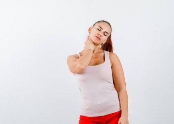 Woman in a tank top massaging her neck.