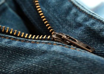 Close-up of a blue denim jeans zipper slightly undone.