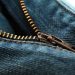 Close-up of a blue denim jeans zipper slightly undone.