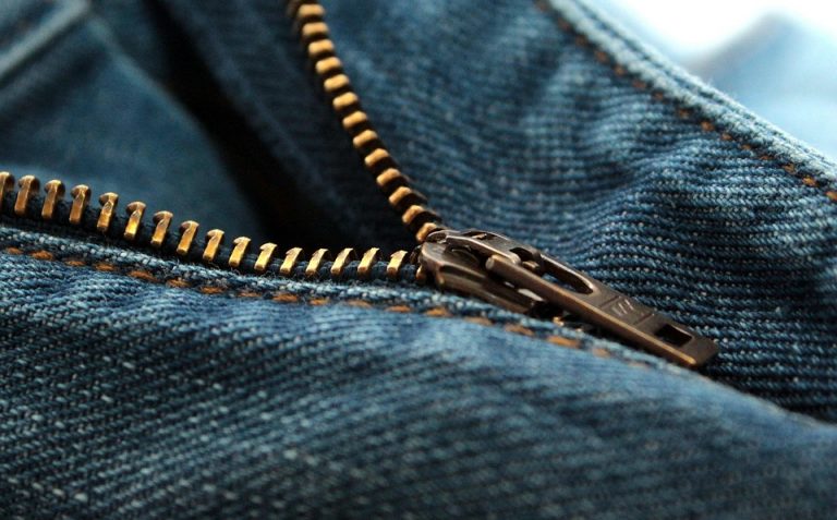 Close-up of a blue denim jeans zipper slightly undone.