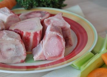 Bone marrow and vegetables arranged for soup preparation.