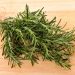 Fresh rosemary herbs on wooden cutting board.