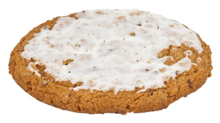 Frosted oatmeal cookie on white background.