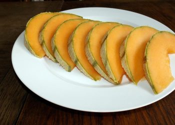 Sliced cantaloupe arranged on a white plate, ready to serve.