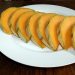 Sliced cantaloupe arranged on a white plate, ready to serve.