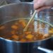 Cooking pumpkin soup in a pot with fresh ingredients.