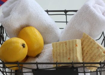 Basket with lemons, rolled towels, and natural soap bars.