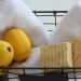 Basket with lemons, rolled towels, and natural soap bars.