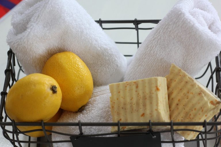 Basket with lemons, rolled towels, and natural soap bars.