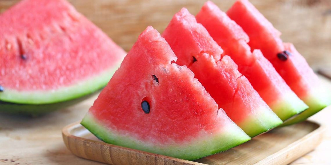 Sliced watermelon on a wooden tray.