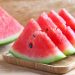 Sliced watermelon on a wooden tray.