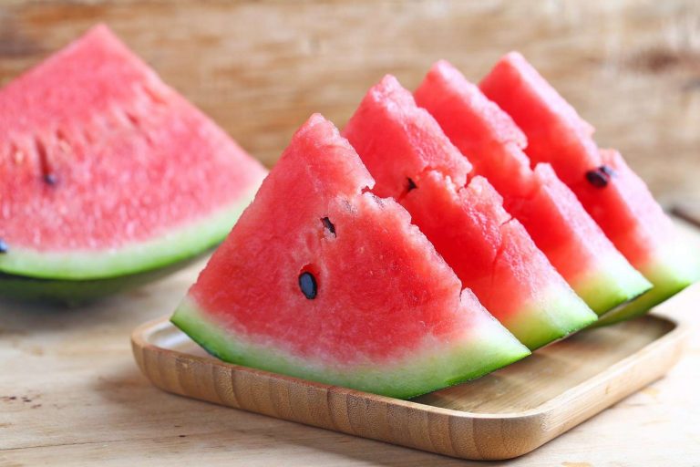 Sliced watermelon on a wooden tray.