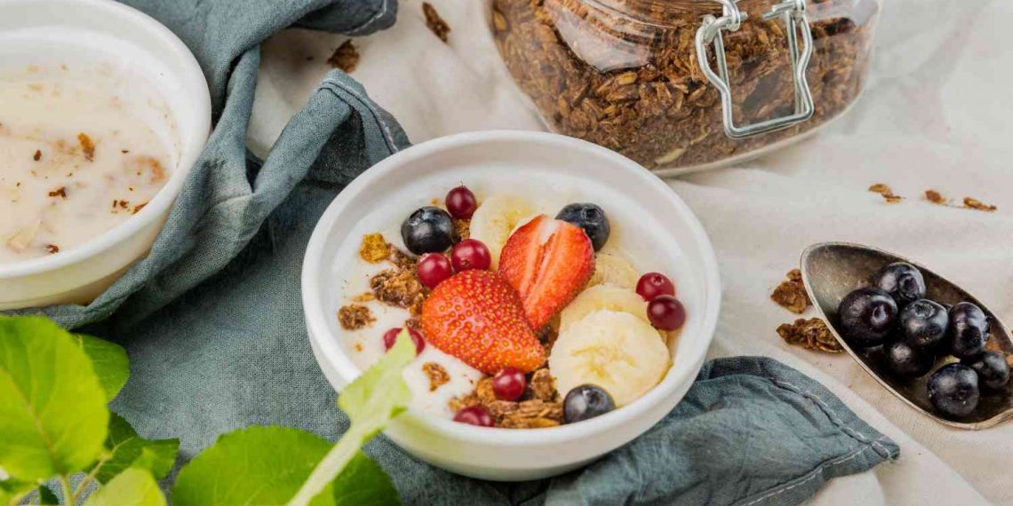 Granola bowl with strawberries, bananas, and blueberries.