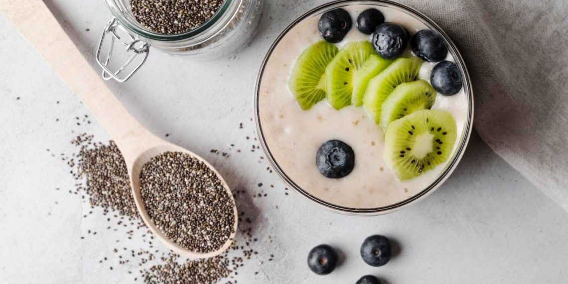 Chia pudding topped with kiwi and blueberries surrounded by seeds.
