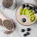 Chia pudding topped with kiwi and blueberries surrounded by seeds.