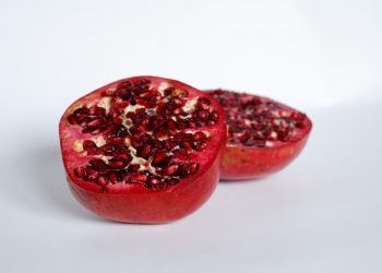 Half pomegranate showcasing vibrant red seeds.