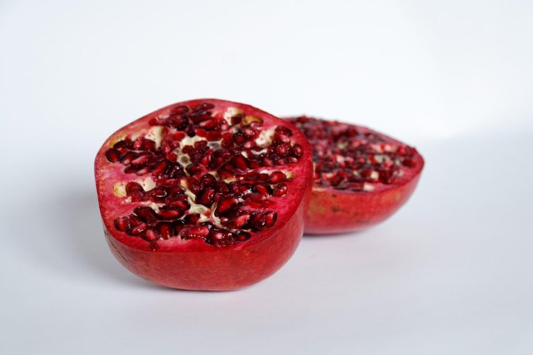 Half pomegranate showcasing vibrant red seeds.