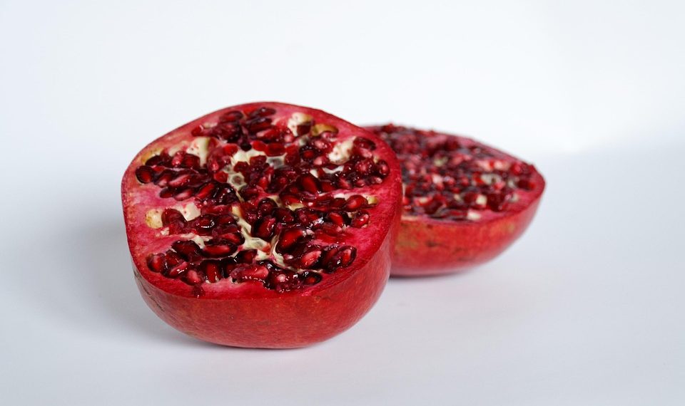 Half pomegranate showcasing vibrant red seeds.