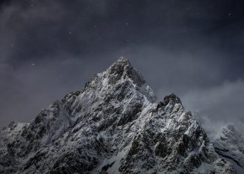 Snow-covered mountain peak under a starry sky.