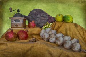 Vintage coffee grinder and fresh produce on a rustic cloth display.
