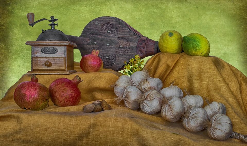 Vintage coffee grinder and fresh produce on a rustic cloth display.