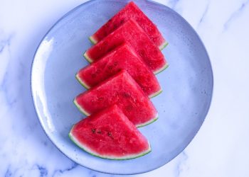 Slices of fresh watermelon arranged on a blue plate.