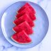 Slices of fresh watermelon arranged on a blue plate.