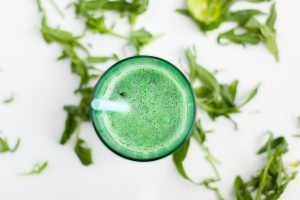 Green smoothie with mint leaves and a blue straw