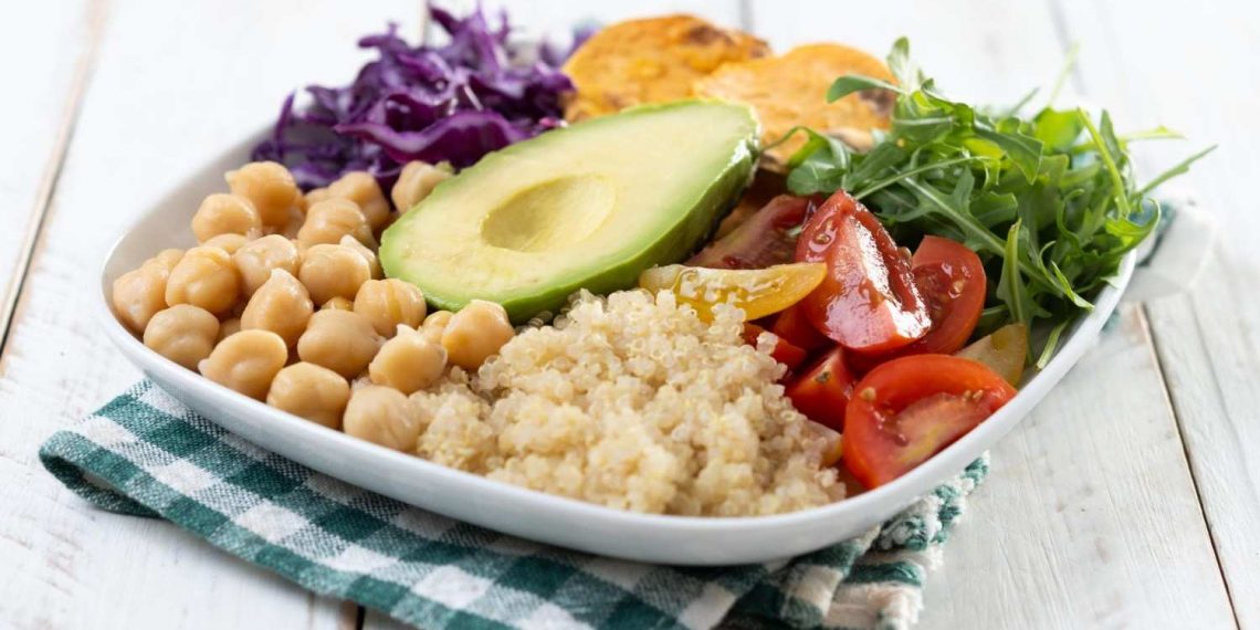 Plate of fresh quinoa salad with avocado, chickpeas, and veggies.