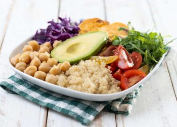 Plate of fresh quinoa salad with avocado, chickpeas, and veggies.