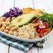 Plate of fresh quinoa salad with avocado, chickpeas, and veggies.