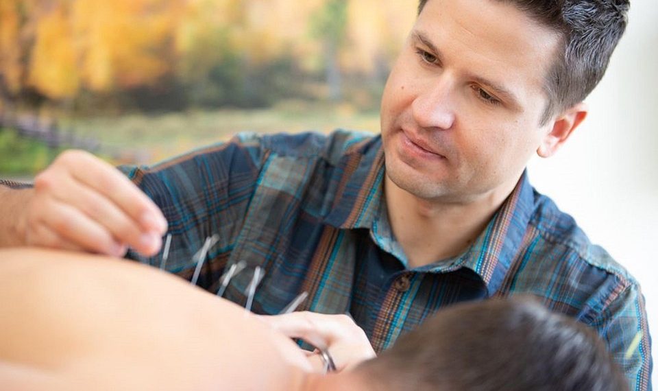 Acupuncturist performing treatment with focus and care.