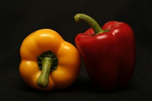 Yellow and red bell peppers on a black background.